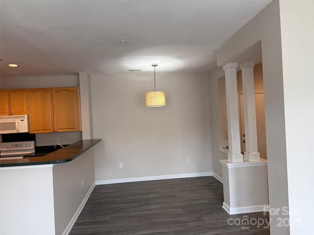 6112 Creft Cir, Indian Trail, NC 28079 - kitchen with white appliances, dark countertops, dark wood-type flooring, decorative light fixtures, and a peninsula