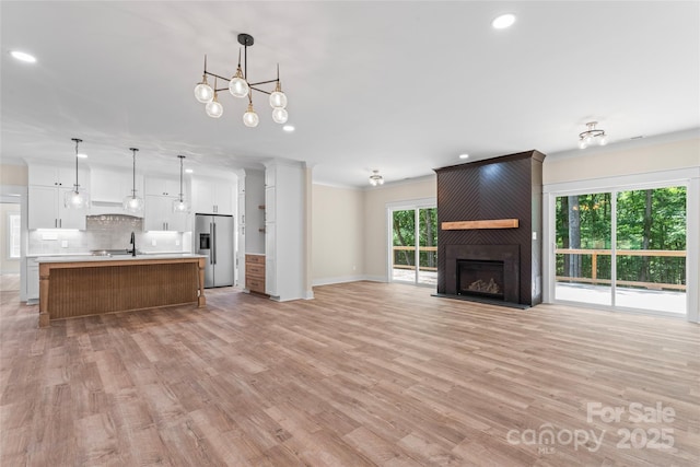 510 State Rd, China Grove, NC 28023 - unfurnished living room with recessed lighting, light wood-style floors, crown molding, and a fireplace