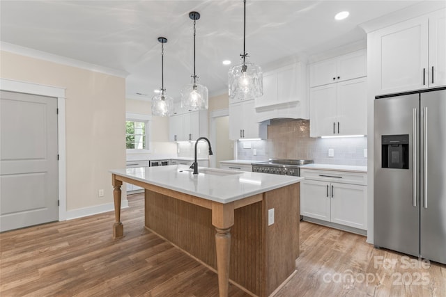 510 State Rd, China Grove, NC 28023 - kitchen with stainless steel appliances, light countertops, tasteful backsplash, light wood-style floors, and a kitchen island with sink