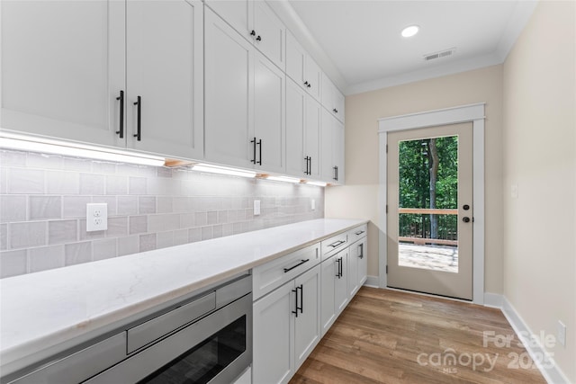 510 State Rd, China Grove, NC 28023 - bar area featuring light wood finished floors, tasteful backsplash, recessed lighting, crown molding, and stainless steel microwave