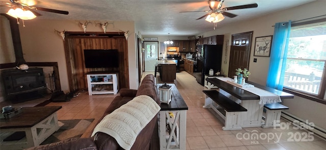 414 Pine Cove Rd, Old Fort, NC 28762 - living area with a ceiling fan, light tile patterned flooring, a wood stove, and plenty of natural light