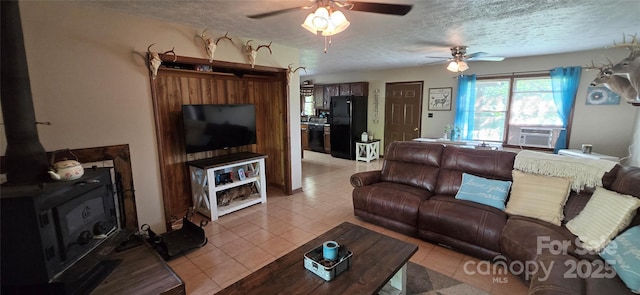 414 Pine Cove Rd, Old Fort, NC 28762 - living area with cooling unit, ceiling fan, a textured ceiling, a wood stove, and light tile patterned flooring