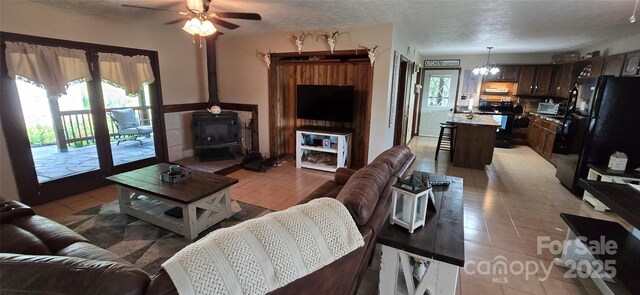 414 Pine Cove Rd, Old Fort, NC 28762 - living area with ceiling fan, a wood stove, light tile patterned flooring, and a textured ceiling