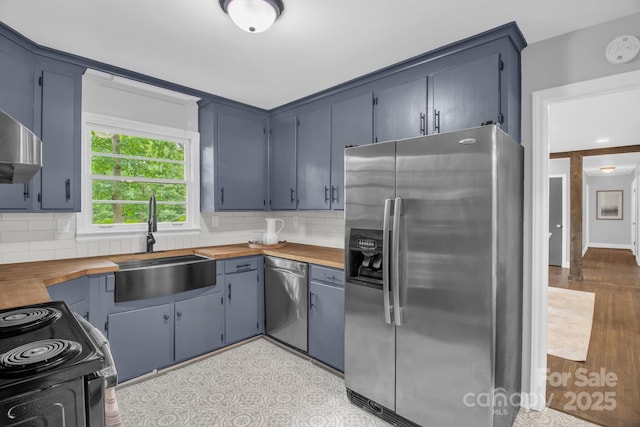 1623 Lumarka Dr, Charlotte, NC 28212 - kitchen featuring appliances with stainless steel finishes, wooden counters, and tasteful backsplash