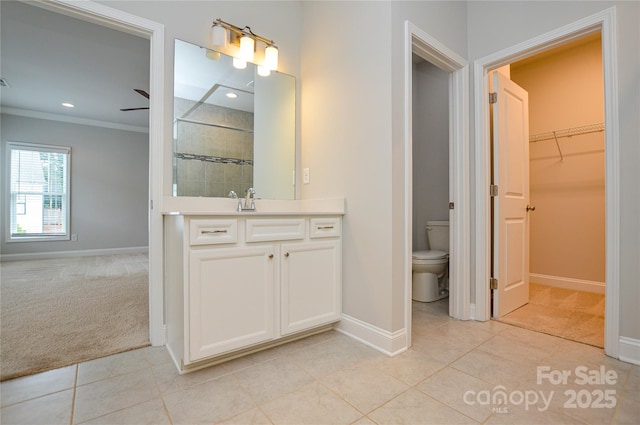 10149 Meeting House Dr NW, Huntersville, NC 28078 - bathroom featuring a tile shower, tile patterned floors, vanity, ornamental molding, and a walk in closet