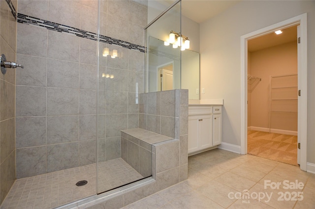 10149 Meeting House Dr NW, Huntersville, NC 28078 - bathroom with tiled shower, vanity, tile patterned flooring, and a walk in closet