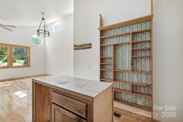 109 Azalea Ave, Swannanoa, NC 28778 - kitchen with light wood finished floors, a ceiling fan, tile countertops, decorative light fixtures, and open shelves