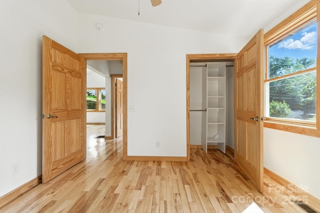 109 Azalea Ave, Swannanoa, NC 28778 - unfurnished bedroom featuring light wood-type flooring, multiple windows, and a ceiling fan
