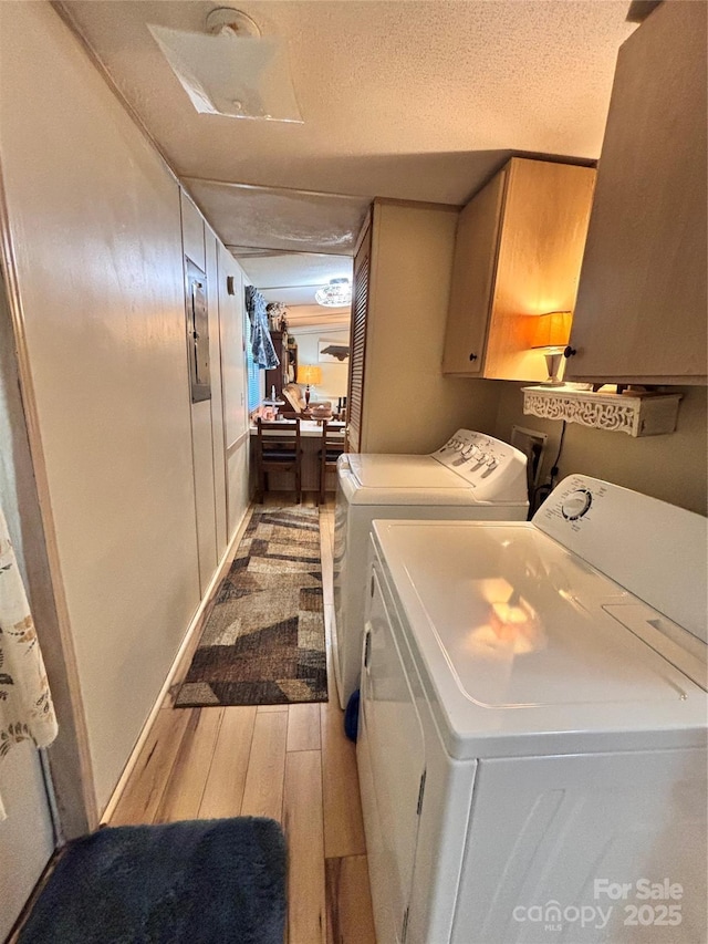 1890 Bud Tilley Rd, Pinnacle, NC 27043 - laundry room with cabinet space, washing machine and clothes dryer, wood finished floors, and a textured ceiling