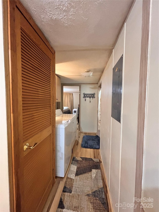 1890 Bud Tilley Rd, Pinnacle, NC 27043 - laundry room featuring washing machine and clothes dryer, light wood-style flooring, cabinet space, electric panel, and a textured ceiling