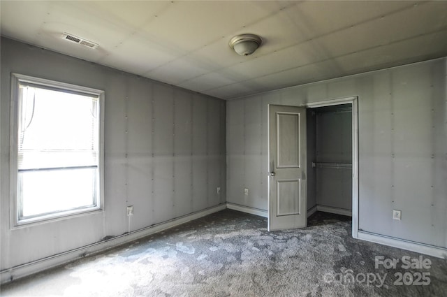 551 Sylvan St SW, Concord, NC 28025 - unfurnished bedroom featuring multiple windows, carpet floors, and a closet