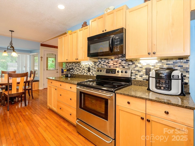 1047 Honeybee Trl, Fort Mill, SC 29715 - kitchen with black microwave, stainless steel range with electric cooktop, light brown cabinetry, backsplash, and a textured ceiling