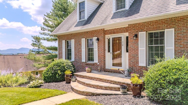 74 Challedon Dr, Candler, NC 28715 - view of exterior entry featuring brick siding, a mountain view, and a shingled roof