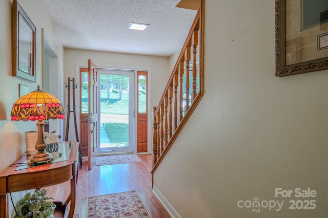 74 Challedon Dr, Candler, NC 28715 - foyer featuring wood finished floors, a textured ceiling, and stairs