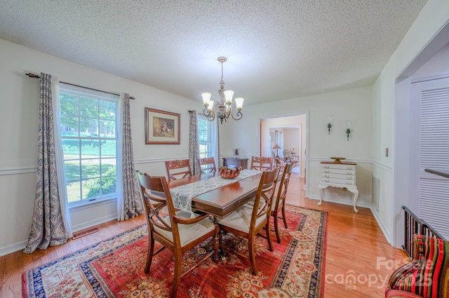 74 Challedon Dr, Candler, NC 28715 - dining area featuring a chandelier, a textured ceiling, and light wood-style floors