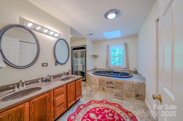 74 Challedon Dr, Candler, NC 28715 - bathroom with a skylight, double vanity, a garden tub, and a textured ceiling