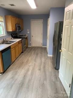 1422 Mitchell Glen St, Kannapolis, NC 28083 - kitchen with appliances with stainless steel finishes, light wood-type flooring, brown cabinetry, and light countertops