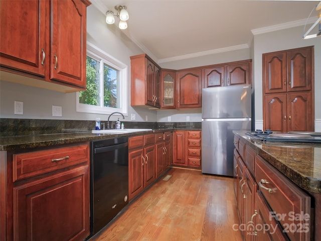 6620 Amos Smith Rd, Charlotte, NC 28214 - kitchen with appliances with stainless steel finishes, crown molding, light wood-style floors, dark stone countertops, and glass insert cabinets