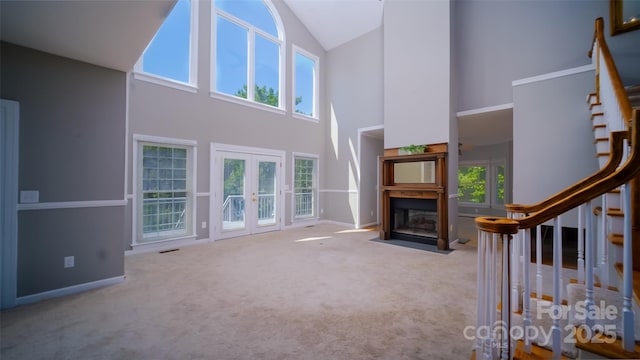 6620 Amos Smith Rd, Charlotte, NC 28214 - unfurnished living room with high vaulted ceiling, stairs, french doors, carpet floors, and a fireplace with flush hearth