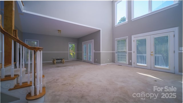 6620 Amos Smith Rd, Charlotte, NC 28214 - unfurnished living room with french doors, stairs, carpet floors, and a high ceiling