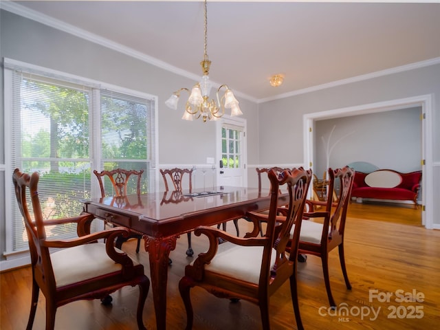 6620 Amos Smith Rd, Charlotte, NC 28214 - dining room with crown molding, a chandelier, light wood finished floors, and a wainscoted wall