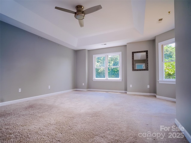 6620 Amos Smith Rd, Charlotte, NC 28214 - empty room with a tray ceiling, healthy amount of natural light, ceiling fan, and light carpet