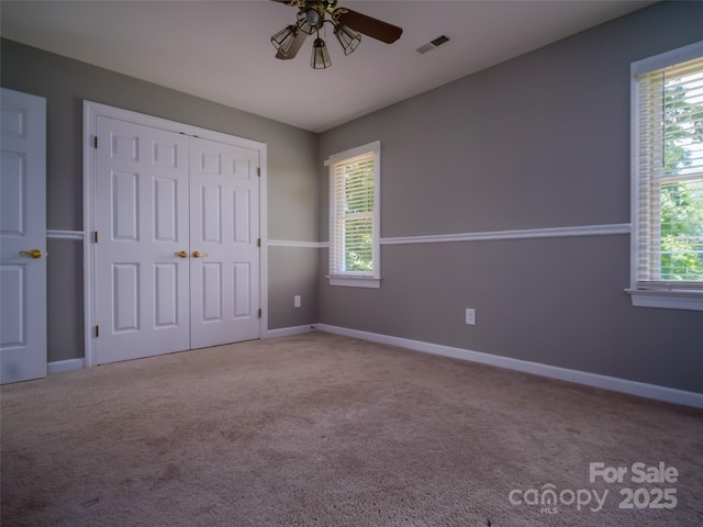 6620 Amos Smith Rd, Charlotte, NC 28214 - unfurnished bedroom with multiple windows, carpet floors, and a closet