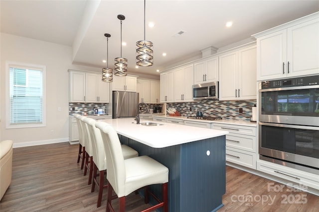 10240 Superb Ln, Charlotte, NC 28215 - kitchen featuring appliances with stainless steel finishes, backsplash, dark wood-style flooring, a breakfast bar, and recessed lighting