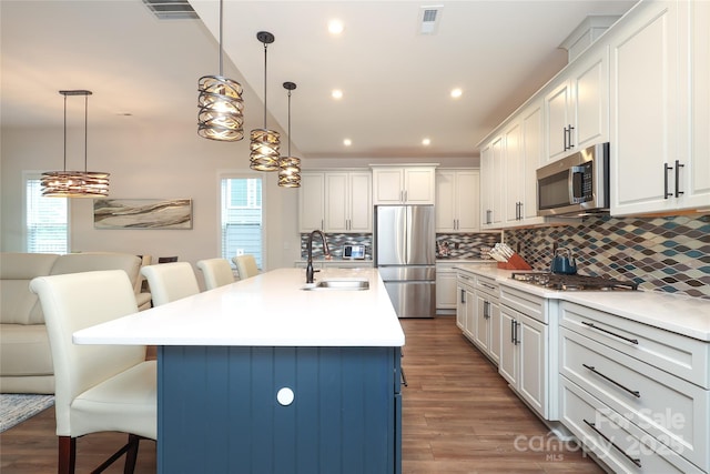 10240 Superb Ln, Charlotte, NC 28215 - kitchen featuring stainless steel appliances, a breakfast bar area, decorative backsplash, dark wood-style floors, and recessed lighting