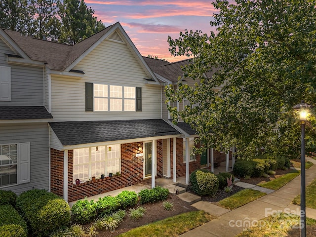 1778 Pergola Pl, Charlotte, NC 28213 - view of front of house featuring a shingled roof, brick siding, and a porch