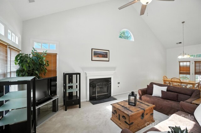3325 Fortis Ln, Matthews, NC 28105 - living room featuring high vaulted ceiling, light carpet, ceiling fan, a chandelier, and a fireplace with flush hearth