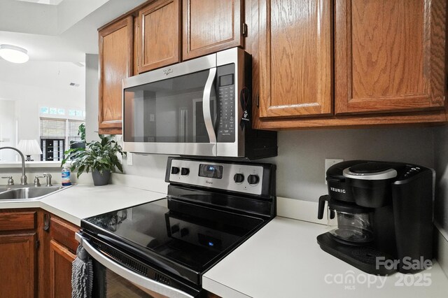 3325 Fortis Ln, Matthews, NC 28105 - kitchen with appliances with stainless steel finishes, light countertops, and brown cabinetry