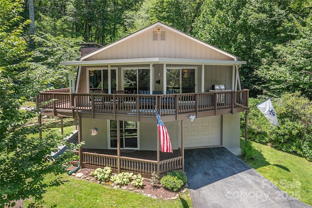 477 Locust Dr, Maggie Valley, NC 28751 - view of front of home with a chimney, a garage, asphalt driveway, a front yard, and a view of trees