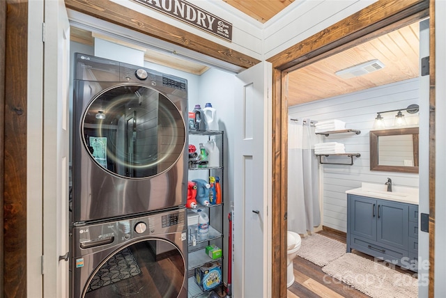 477 Locust Dr, Maggie Valley, NC 28751 - laundry room featuring stacked washer / dryer, wood finished floors, and wooden walls