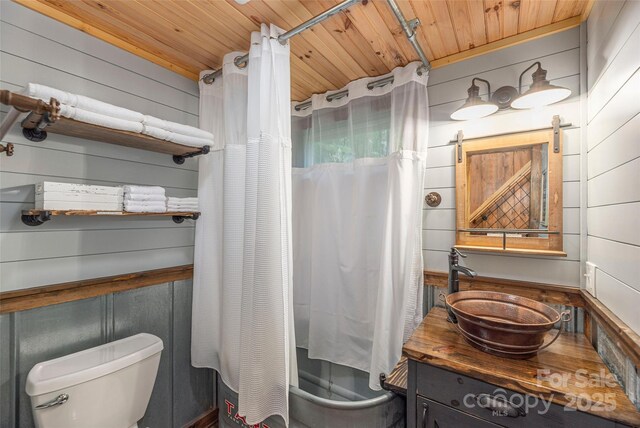 477 Locust Dr, Maggie Valley, NC 28751 - bathroom featuring vanity, wooden ceiling, shower / tub combo with curtain, and wooden walls