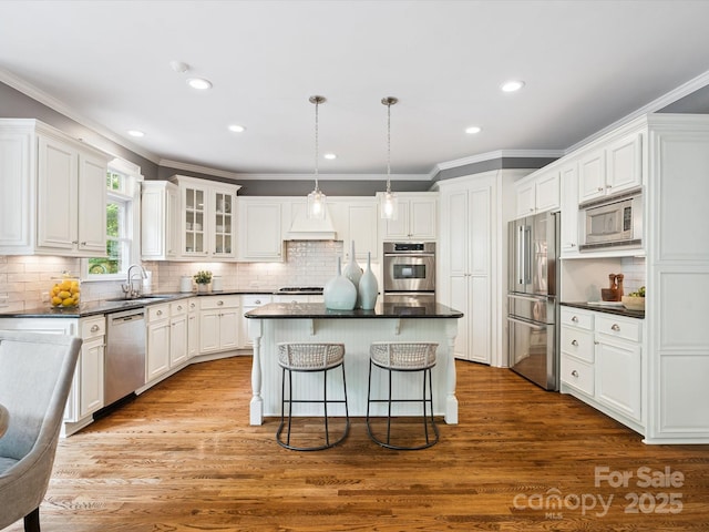 2103 Lytton Ln, Matthews, NC 28104 - kitchen featuring appliances with stainless steel finishes, dark countertops, a kitchen bar, a center island, and white cabinetry