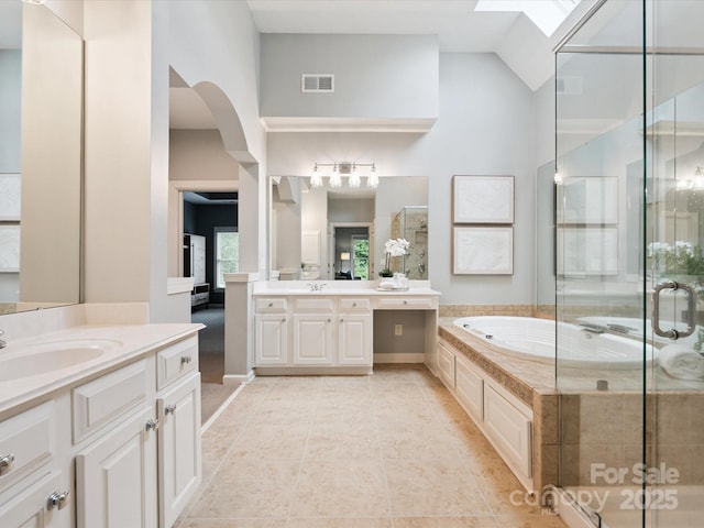 2103 Lytton Ln, Matthews, NC 28104 - full bath featuring two vanities, a garden tub, a stall shower, a skylight, and high vaulted ceiling