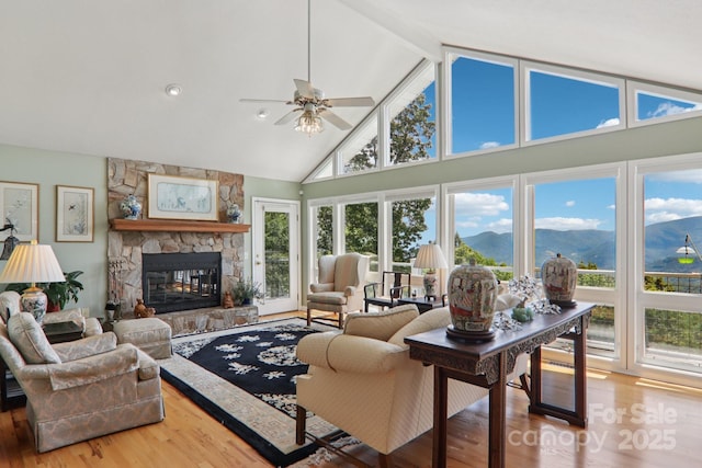 600 Summit Rdg Unit 34, Waynesville, NC 28786 - living area featuring wood finished floors, high vaulted ceiling, healthy amount of natural light, a fireplace, and a ceiling fan
