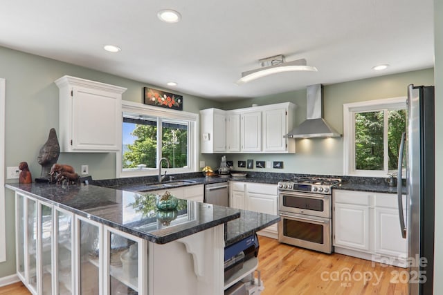 600 Summit Rdg Unit 34, Waynesville, NC 28786 - kitchen with wall chimney range hood, appliances with stainless steel finishes, a peninsula, healthy amount of natural light, and recessed lighting