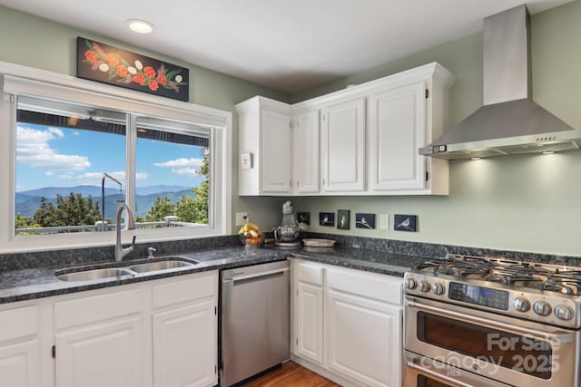 600 Summit Rdg Unit 34, Waynesville, NC 28786 - kitchen featuring wall chimney exhaust hood, appliances with stainless steel finishes, white cabinets, a mountain view, and dark stone counters