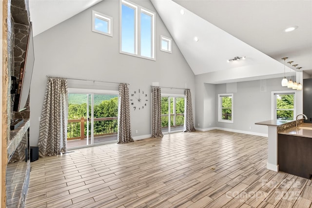 4 Stars Forever Dr, Black Mountain, NC 28711 - unfurnished living room featuring high vaulted ceiling, plenty of natural light, light wood-style flooring, a fireplace, and recessed lighting