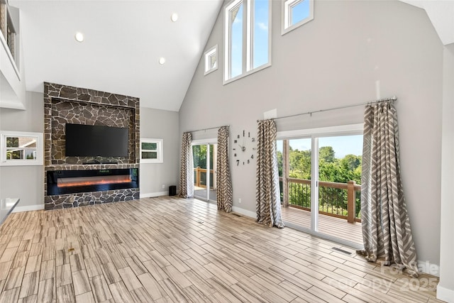 4 Stars Forever Dr, Black Mountain, NC 28711 - unfurnished living room with high vaulted ceiling, a large fireplace, wood finished floors, and recessed lighting