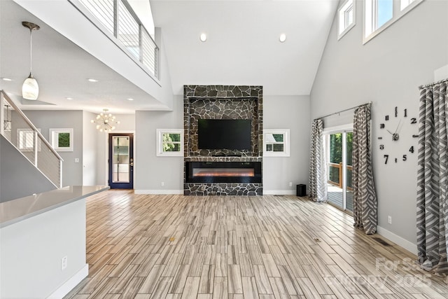4 Stars Forever Dr, Black Mountain, NC 28711 - unfurnished living room with a high ceiling, wood finish floors, stairway, a glass covered fireplace, and recessed lighting