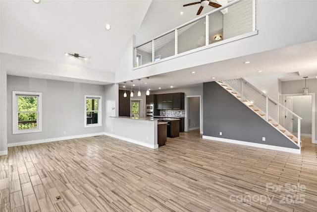 4 Stars Forever Dr, Black Mountain, NC 28711 - unfurnished living room featuring ceiling fan, light wood-style flooring, stairs, high vaulted ceiling, and recessed lighting