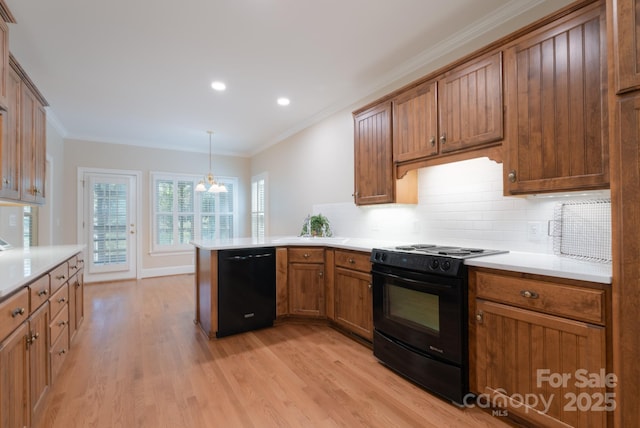 1503 Jack White Dr, Rock Hill, SC 29732 - kitchen featuring black appliances, a peninsula, light wood-type flooring, decorative backsplash, and ornamental molding