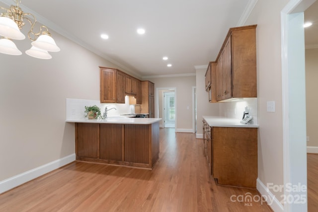 1503 Jack White Dr, Rock Hill, SC 29732 - kitchen featuring brown cabinetry, light countertops, light wood-type flooring, a peninsula, and crown molding