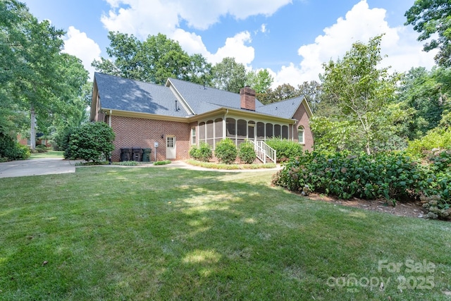 1503 Jack White Dr, Rock Hill, SC 29732 - back of property with a sunroom, brick siding, a chimney, and a lawn