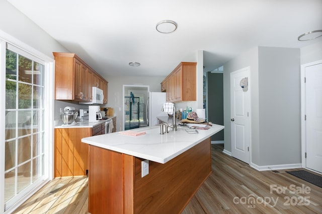2949 Glenstone Dr, Rock Hill, SC 29730 - kitchen with white appliances, wood finished floors, and brown cabinetry