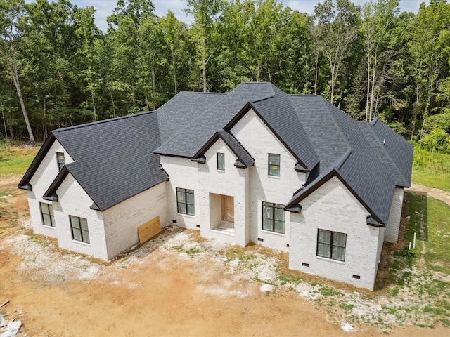 8018 Fairmont Dr, Waxhaw, NC 28173 - french country home with brick siding, roof with shingles, and a wooded view