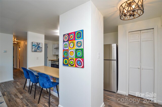 9325 Old Concord Rd Unit J, Charlotte, NC 28213 - kitchen with freestanding refrigerator, dark wood-style flooring, a kitchen breakfast bar, and a chandelier
